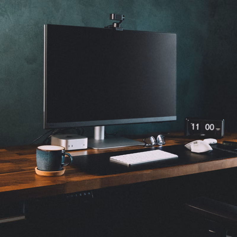 Ethan Suero's desk: a monitor, keyboard and coffee on a walnut top.