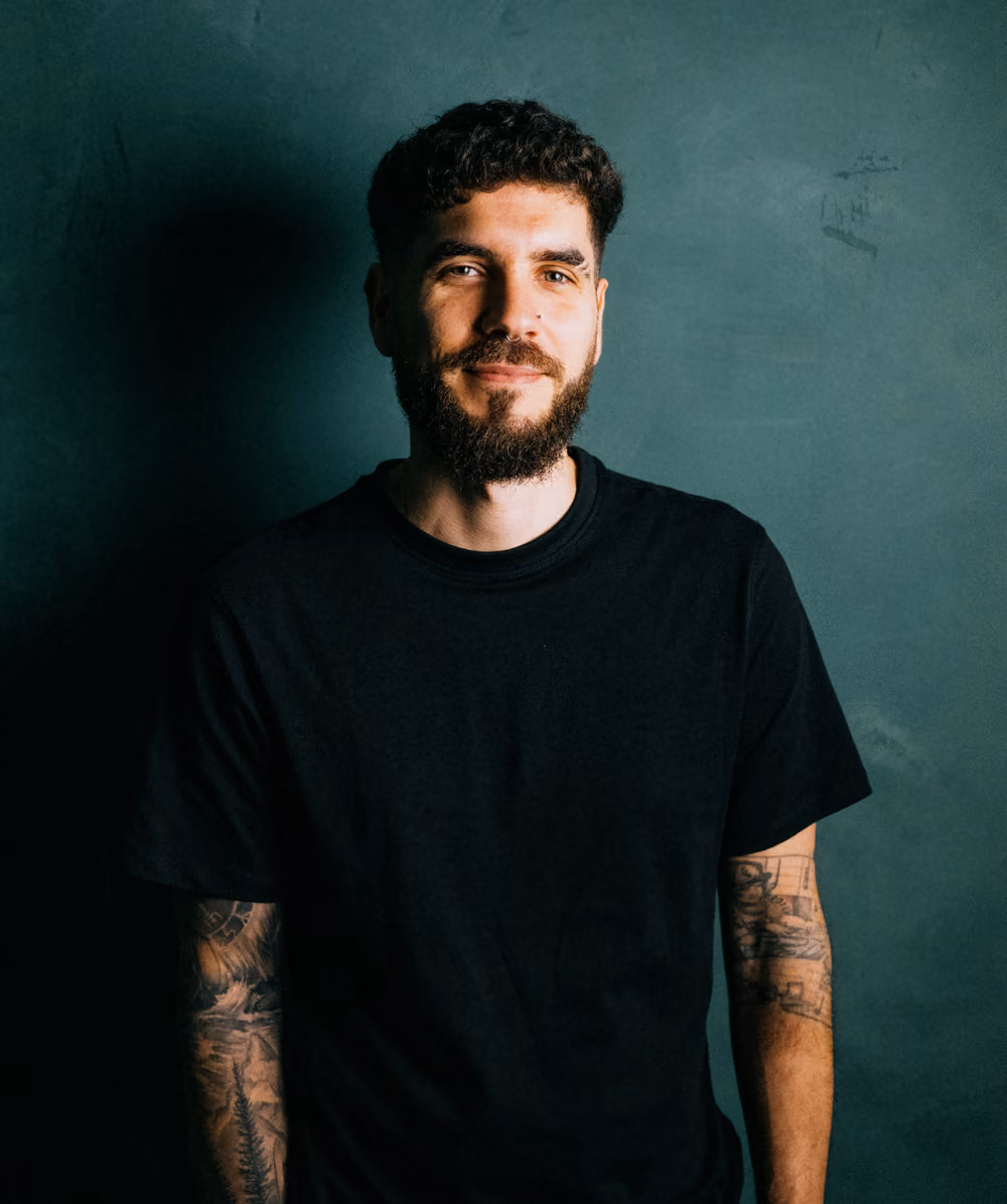 Ethan Suero standing against a dark green wall.